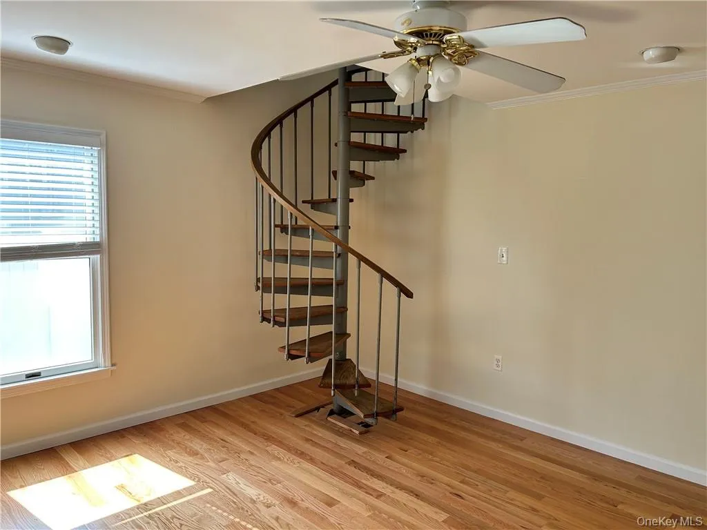 Staircase featuring ceiling fan, ornamental molding, light hardwood / wood-style floors, and a wealth of natural light Staircase featuring ceiling fan, ornamental molding, light hardwood / wood-style floors, and a wealth of natural light