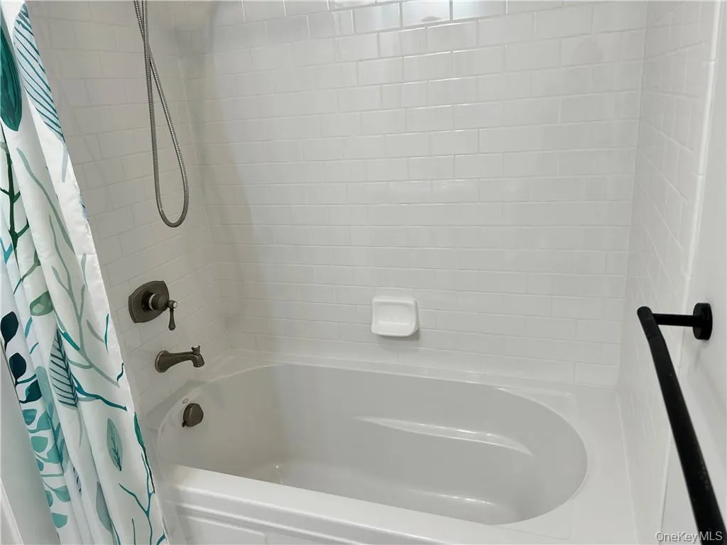 Bathroom featuring shower / bathtub combination with curtain Bathroom featuring shower / bathtub combination with curtain