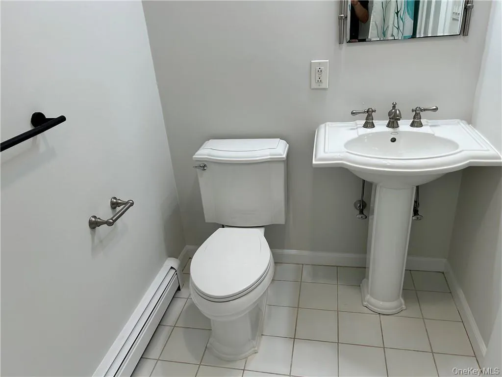 Bathroom featuring tile floors, baseboard heating, and toilet Bathroom featuring tile floors, baseboard heating, and toilet