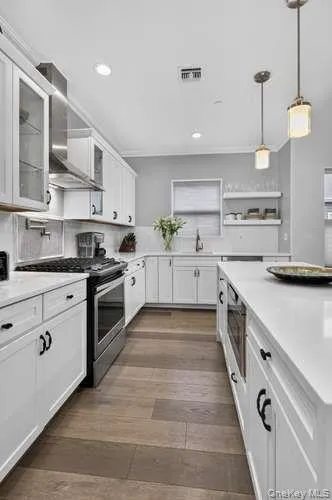 With Pendant Lighting. Custom Features like Pot Filler, Shelving, and Reconfiguration of Cabinets. With Pendant Lighting. Custom Features like Pot Filler, Shelving, and Reconfiguration of Cabinets.