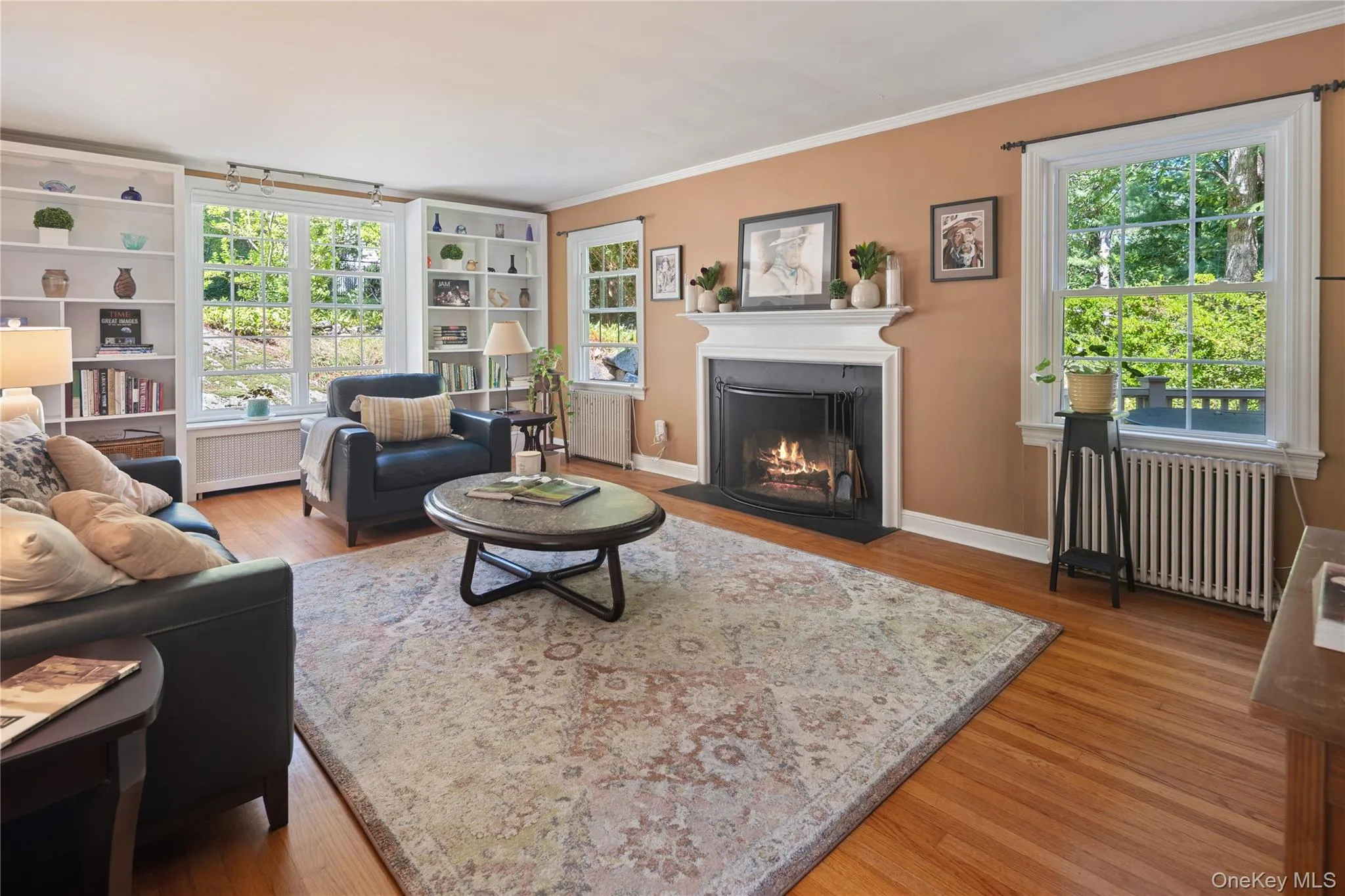 Built-in bookcases and oversized windows with backyard garden views are highlights of the living room. Built-in bookcases and oversized windows with backyard garden views are highlights of the living room.