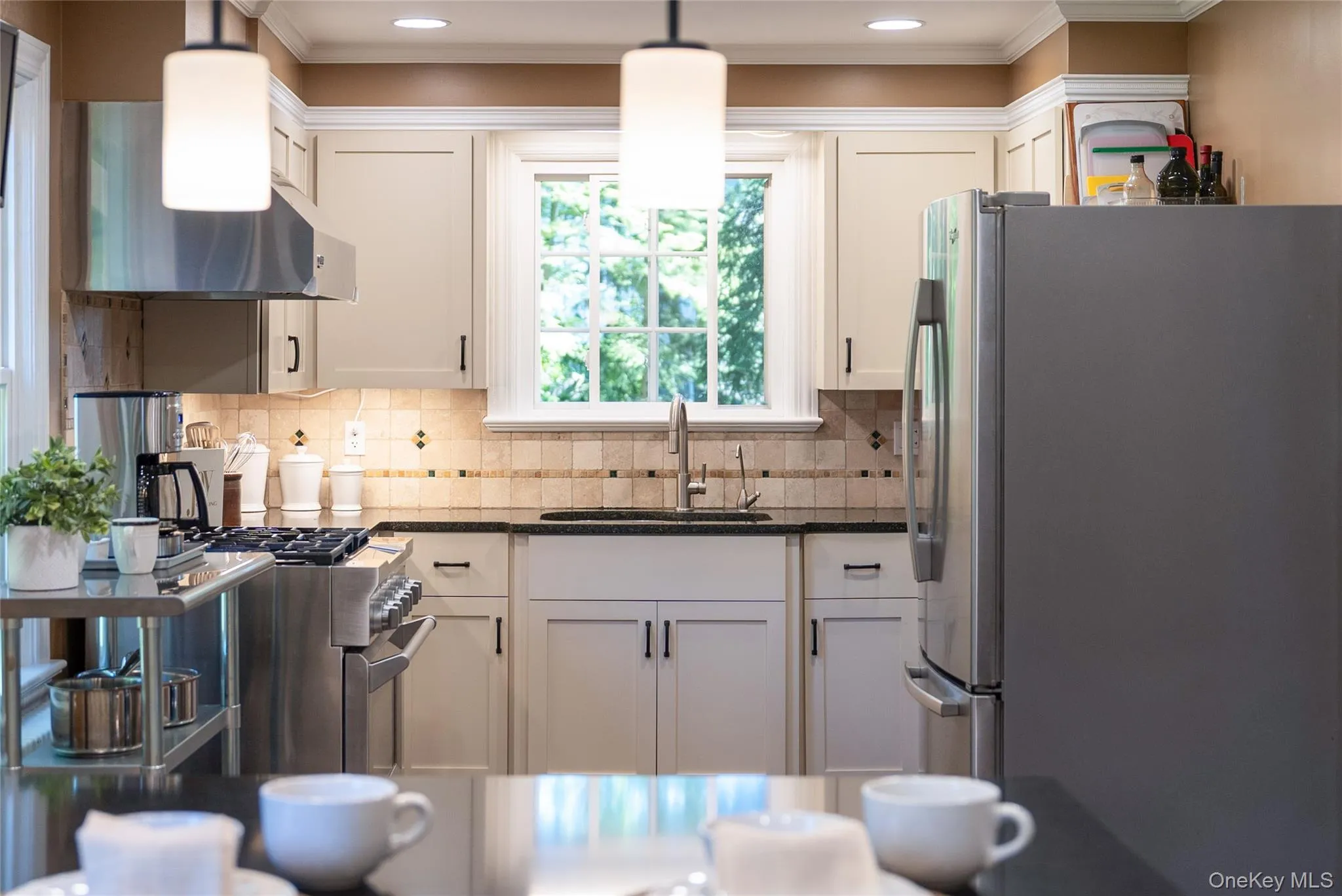 The window over the sink and natural stone tile backsplash add to the refined details and inviting warmth. The window over the sink and natural stone tile backsplash add to the refined details and inviting warmth.