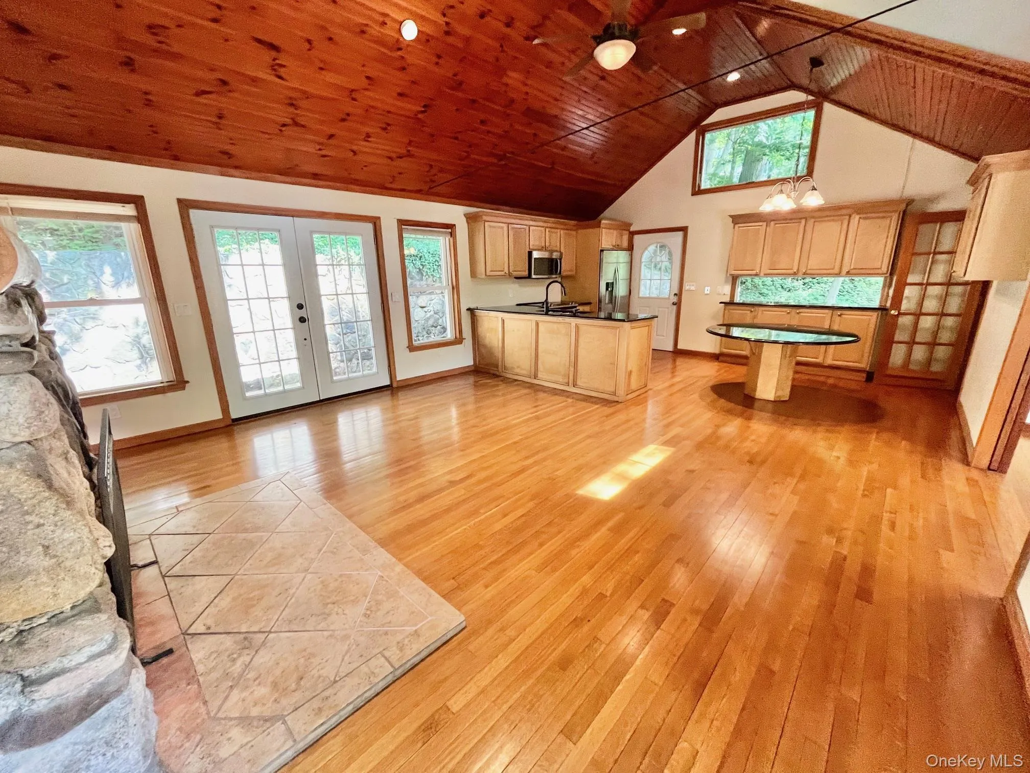 Kitchen featuring stainless steel appliances, light wood finished floors, wood ceiling, a sink, and french doors Kitchen featuring stainless steel appliances, light wood finished floors, wood ceiling, a sink, and french doors