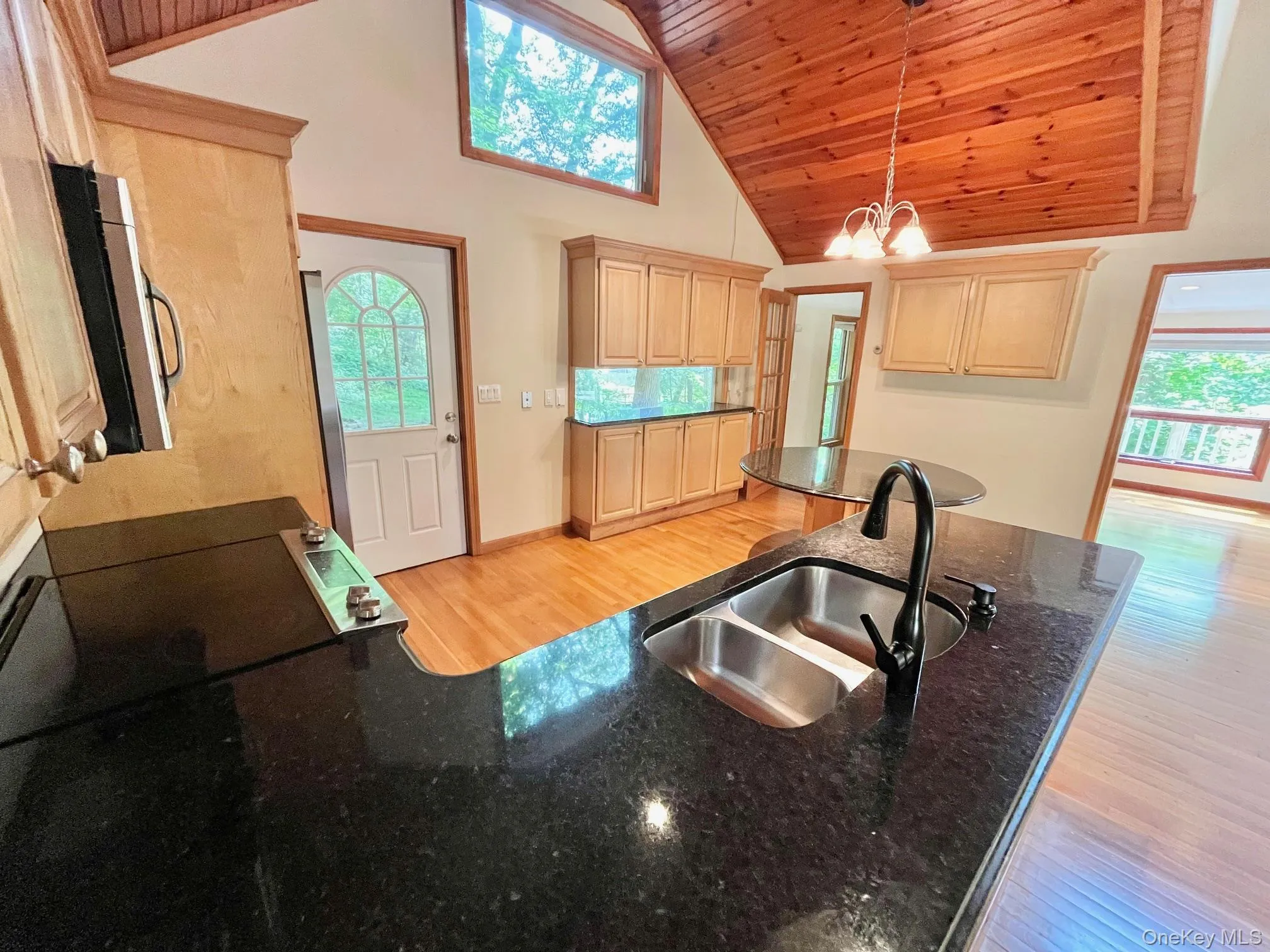 Kitchen featuring light brown cabinetry, light wood-style flooring, a sink, wood ceiling, and a chandelier Kitchen featuring light brown cabinetry, light wood-style flooring, a sink, wood ceiling, and a chandelier
