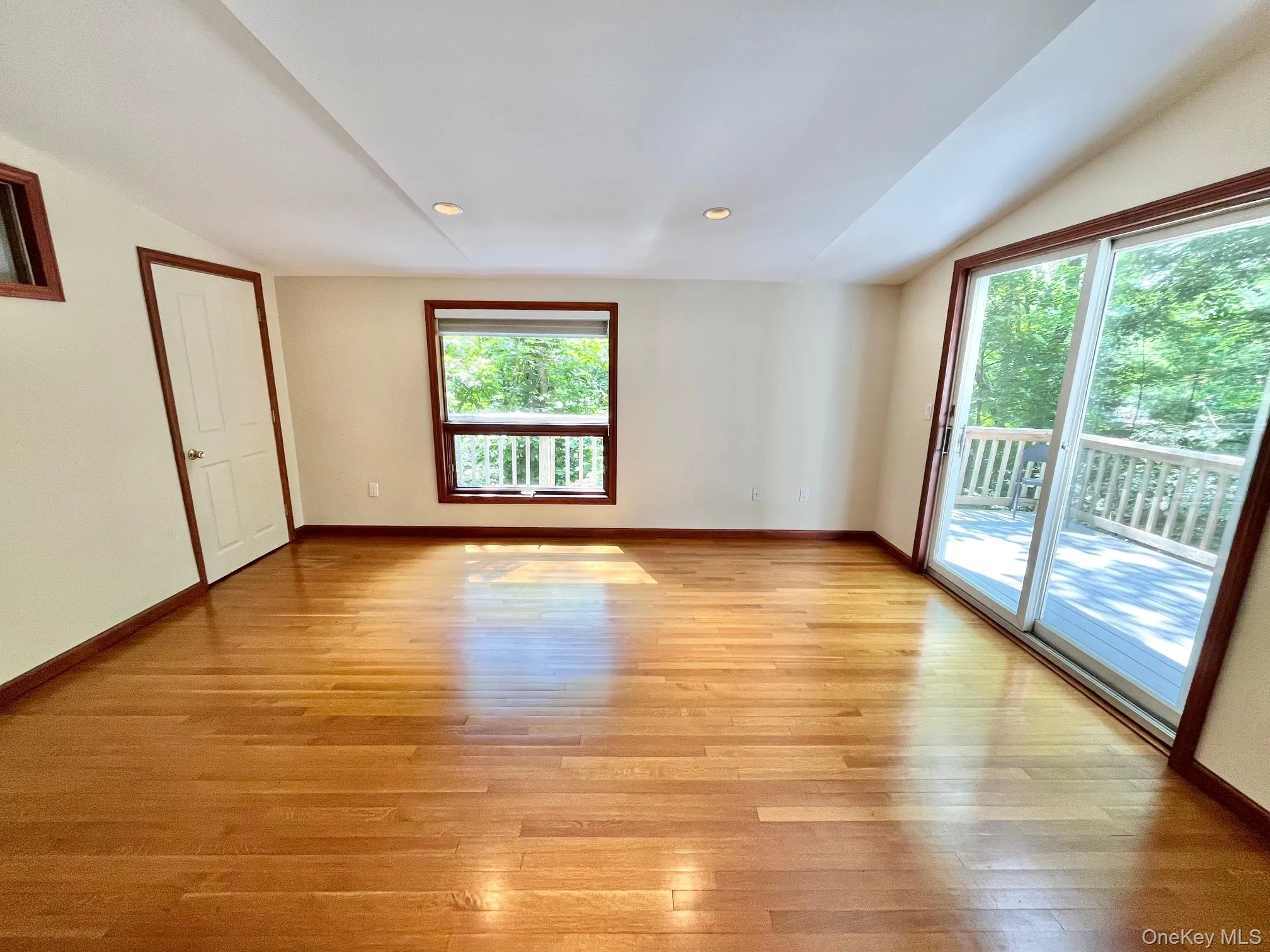 Unfurnished room with vaulted ceiling, light wood-style floors, and baseboards Unfurnished room with vaulted ceiling, light wood-style floors, and baseboards