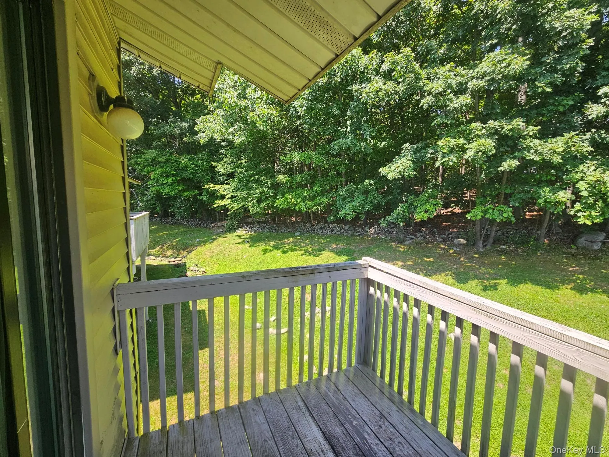 Wooden deck with baluster railing, siding exterior, and extensive treeline Wooden deck with baluster railing, siding exterior, and extensive treeline
