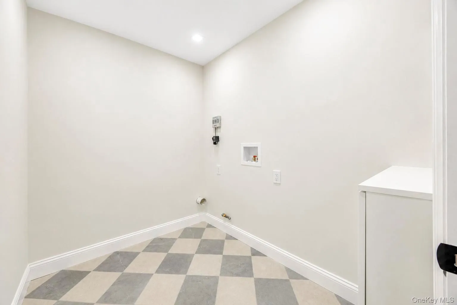 Chequered floor tiles, recessed ceiling light, white baseboards, and built-in cabinetry Chequered floor tiles, recessed ceiling light, white baseboards, and built-in cabinetry