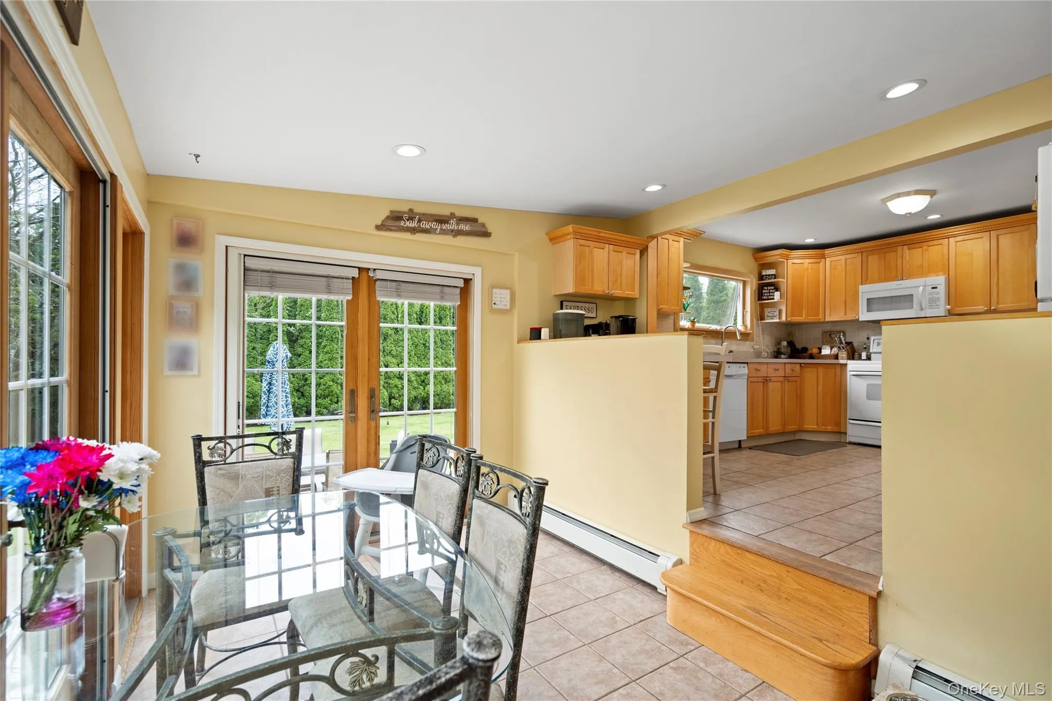 Dining space featuring a baseboard heating unit, light tile patterned flooring, french doors, and recessed lighting Dining space featuring a baseboard heating unit, light tile patterned flooring, french doors, and recessed lighting