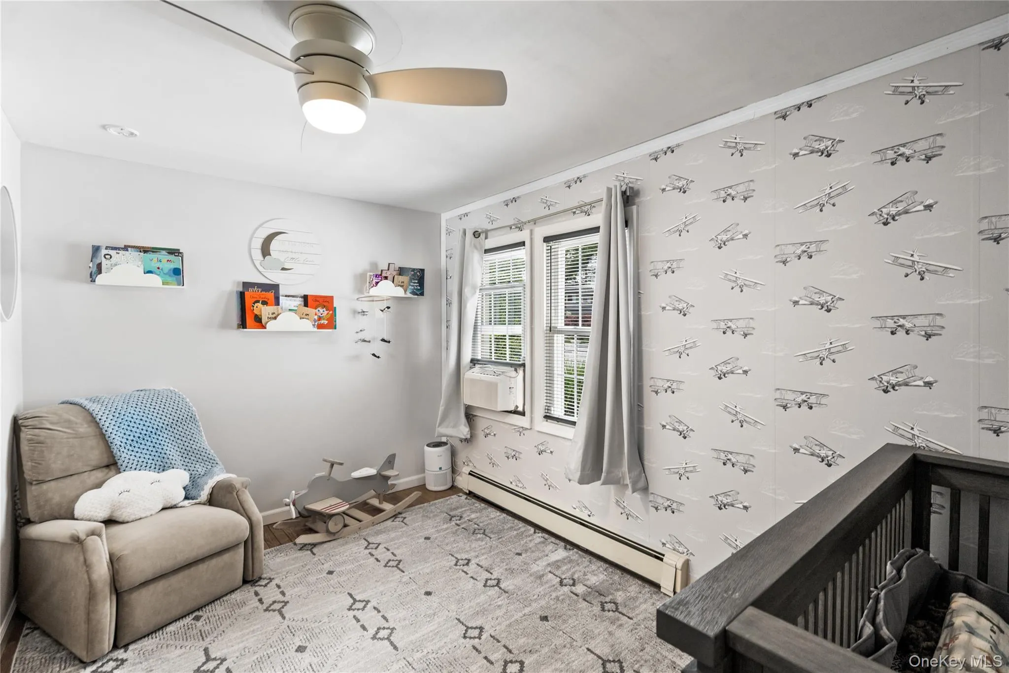 Bedroom featuring a baseboard heating unit, wood finished floors, baseboards, a ceiling fan, and cooling unit Bedroom featuring a baseboard heating unit, wood finished floors, baseboards, a ceiling fan, and cooling unit