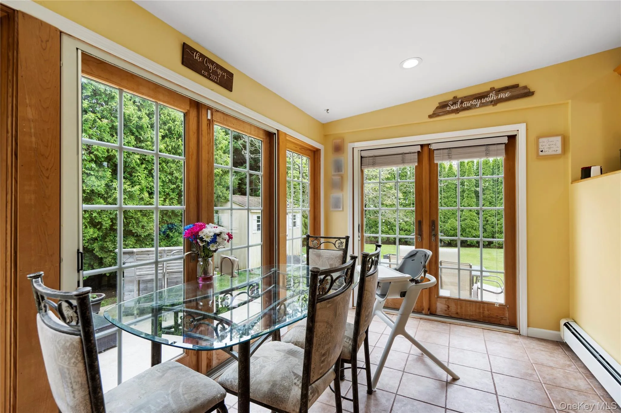 Dining space featuring a baseboard radiator, french doors, light tile patterned floors, baseboards, and recessed lighting Dining space featuring a baseboard radiator, french doors, light tile patterned floors, baseboards, and recessed lighting