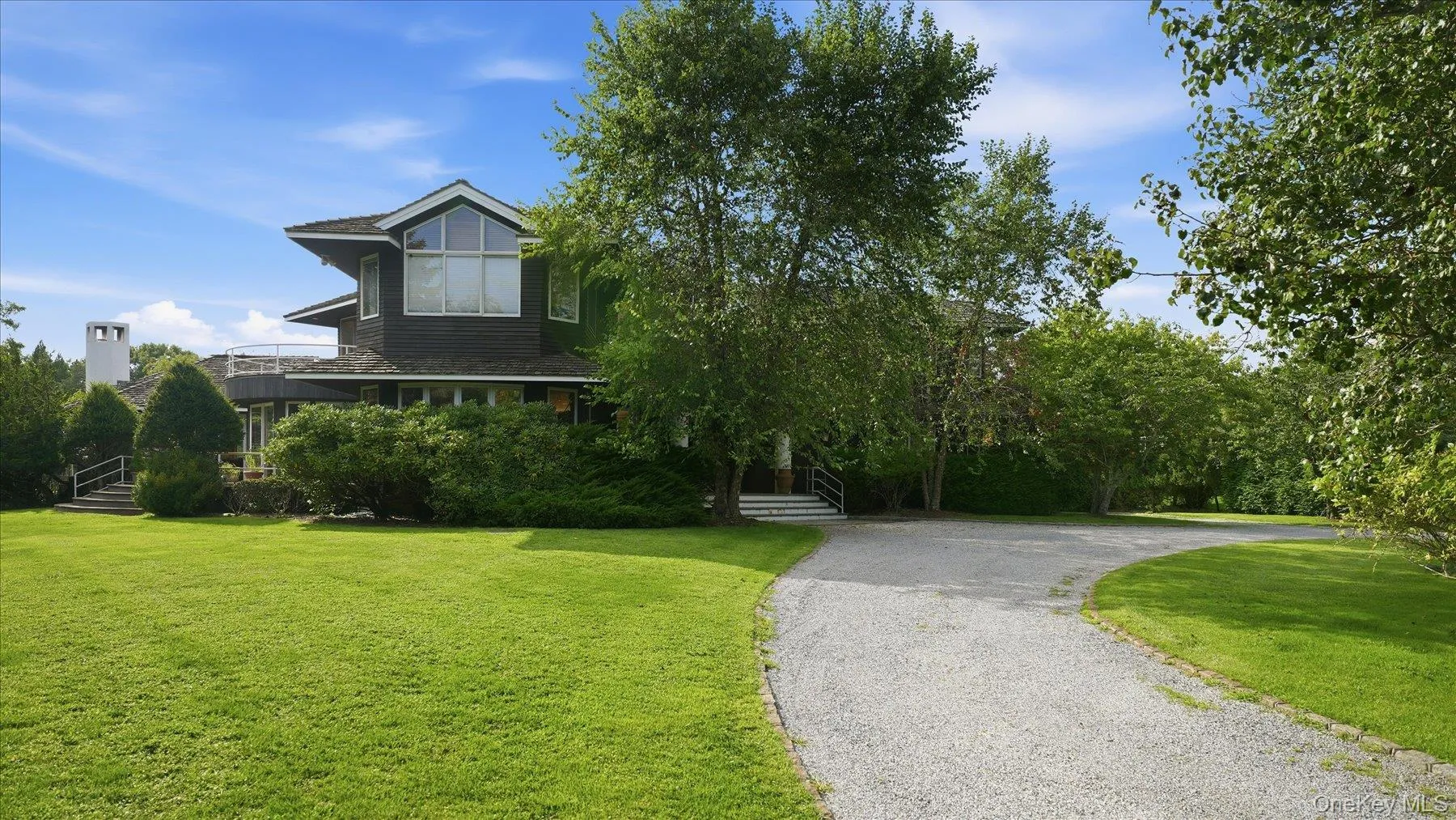 Long driveway with home behind row of mature landscaping Long driveway with home behind row of mature landscaping