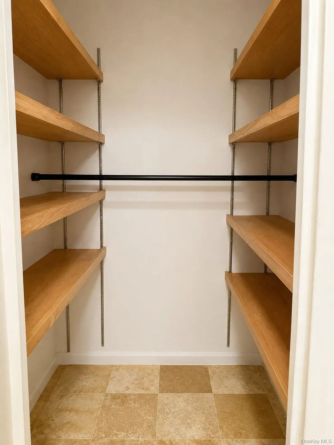 Walk-in closet with built-in wood shelving. Walk-in closet with built-in wood shelving.