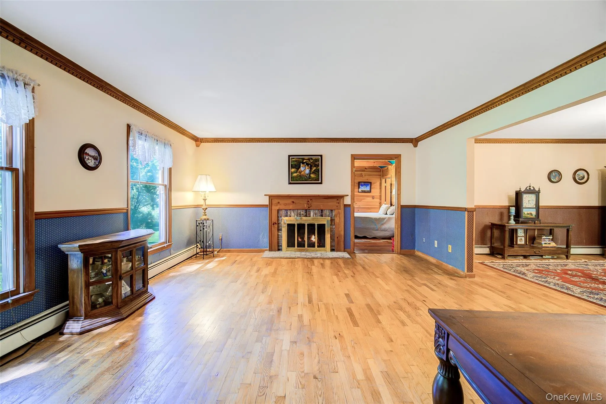 Hardwood flooring, wood-framed windows, wood-mantel fireplace, crown molding, and wainscoting continue the traditional theme of the home Hardwood flooring, wood-framed windows, wood-mantel fireplace, crown molding, and wainscoting continue the traditional theme of the home