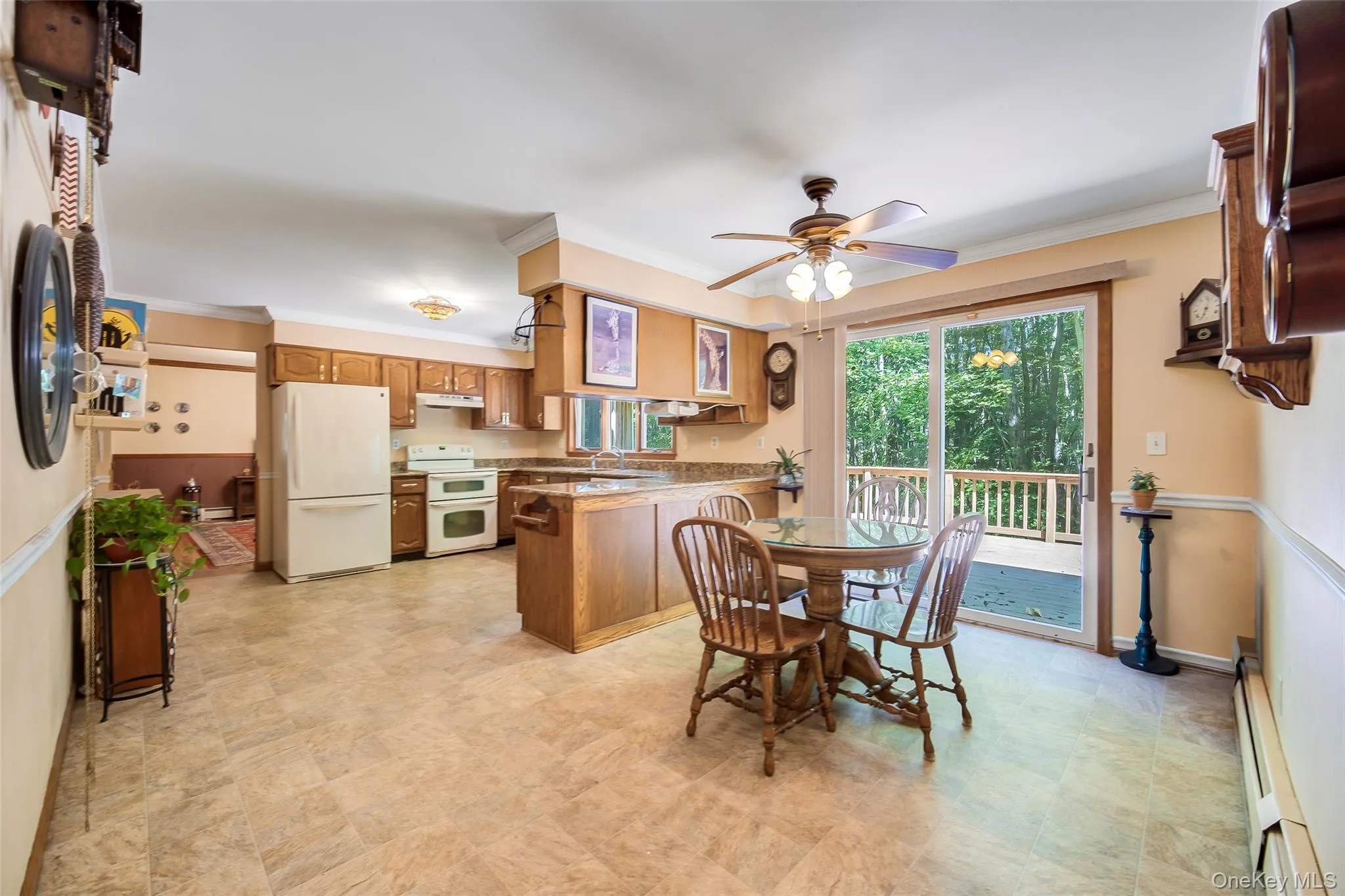 Kitchen featuring wood cabinetry, white appliances, and a tile styled lv flooring Kitchen featuring wood cabinetry, white appliances, and a tile styled lv flooring