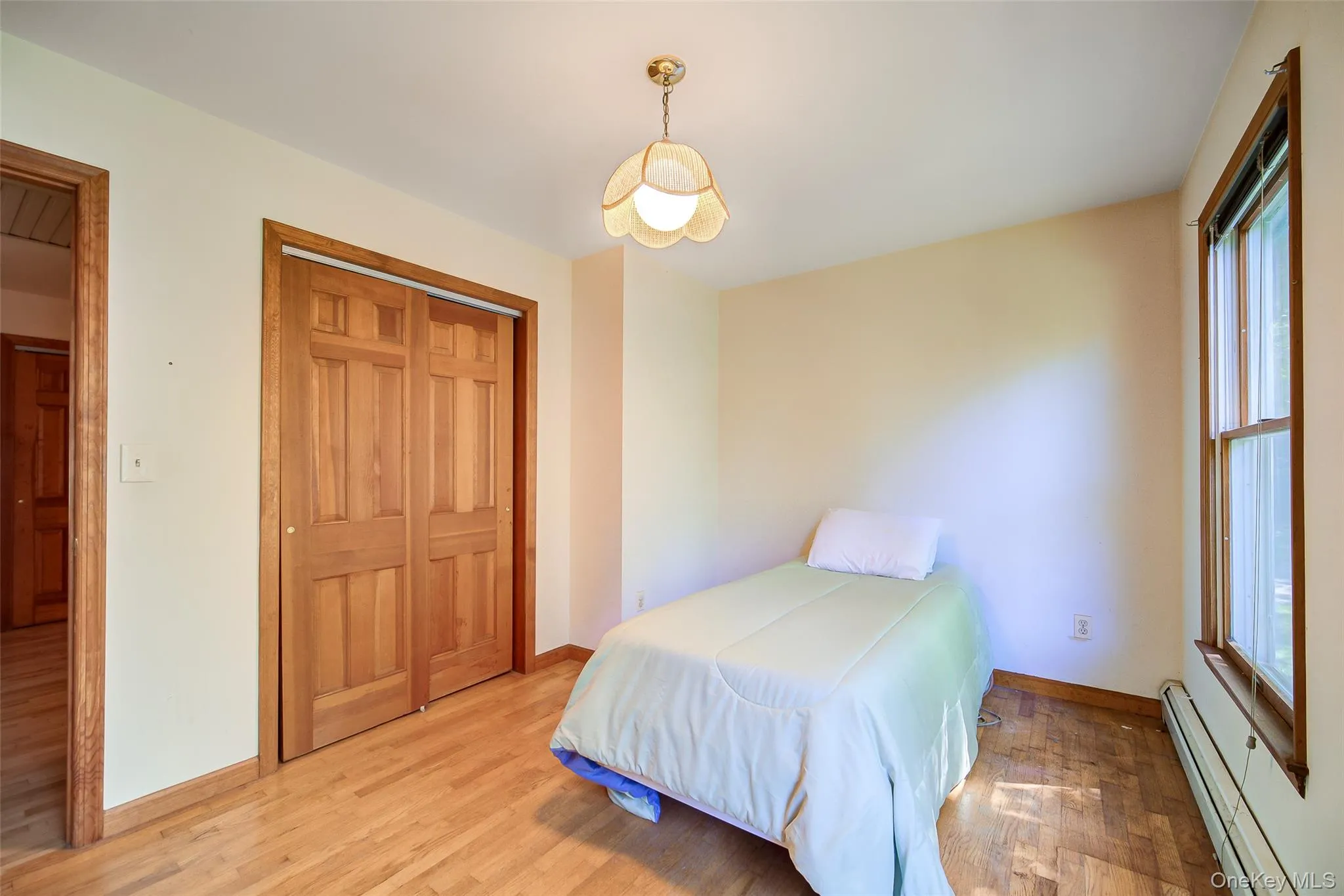 Wood-finish flooring, spacious closet with wood doors, and a wood trimmed window Wood-finish flooring, spacious closet with wood doors, and a wood trimmed window