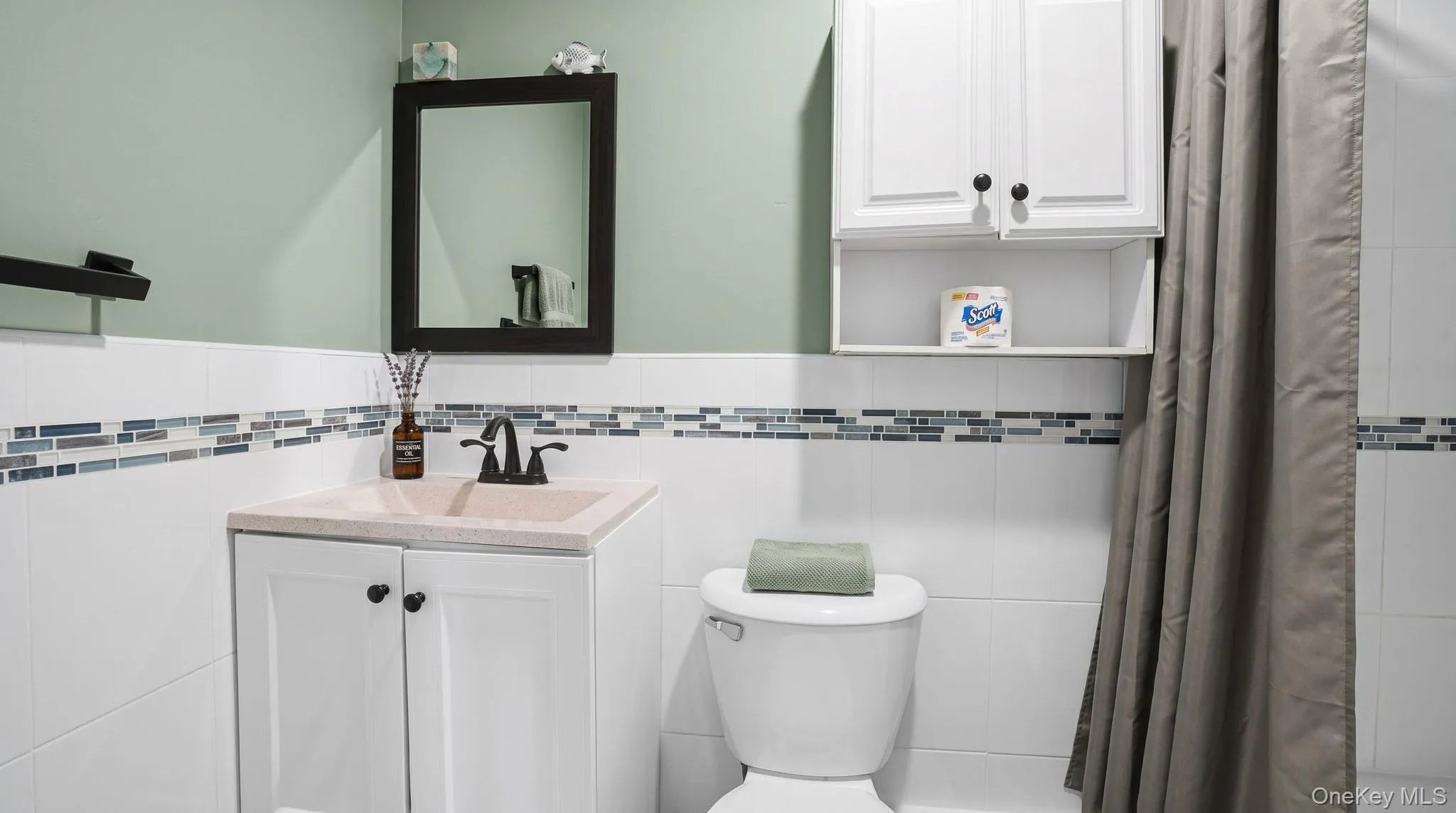 White vanity with integrated sink, black faucet, and white cabinetry White vanity with integrated sink, black faucet, and white cabinetry