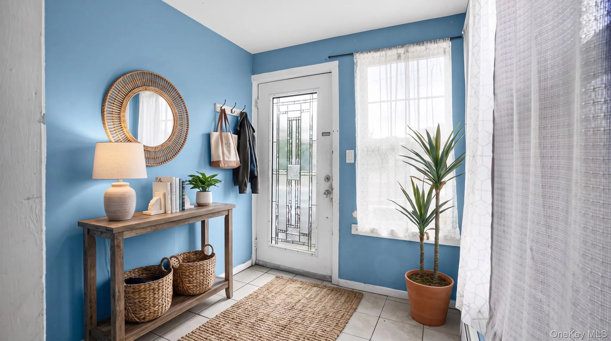 Entryway featuring tile flooring, a window, and a glass-paneled door Entryway featuring tile flooring, a window, and a glass-paneled door