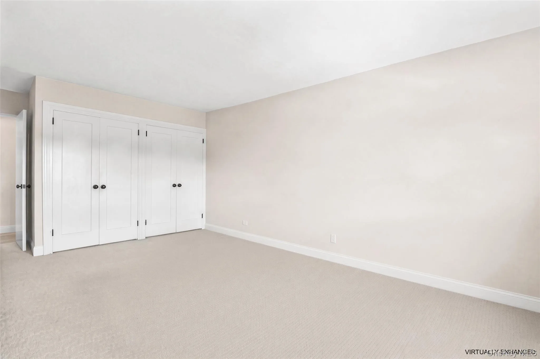 Carpeted bedroom,two double-door closets.Furniture digitally removed Carpeted bedroom,two double-door closets.Furniture digitally removed