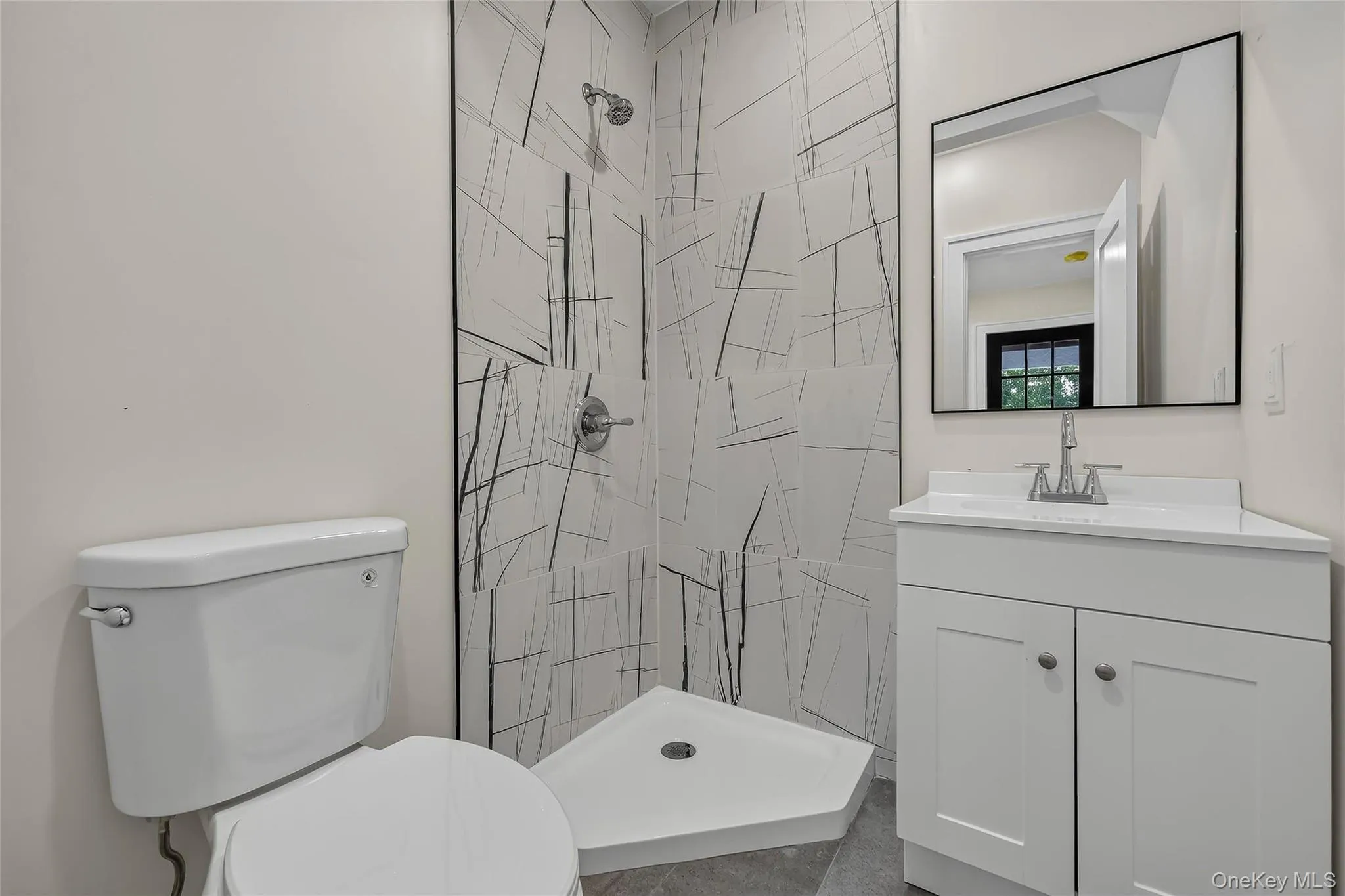 Modern bathroom featuring a corner shower with abstract tilework, a white shower pan, and chrome fixtures Modern bathroom featuring a corner shower with abstract tilework, a white shower pan, and chrome fixtures