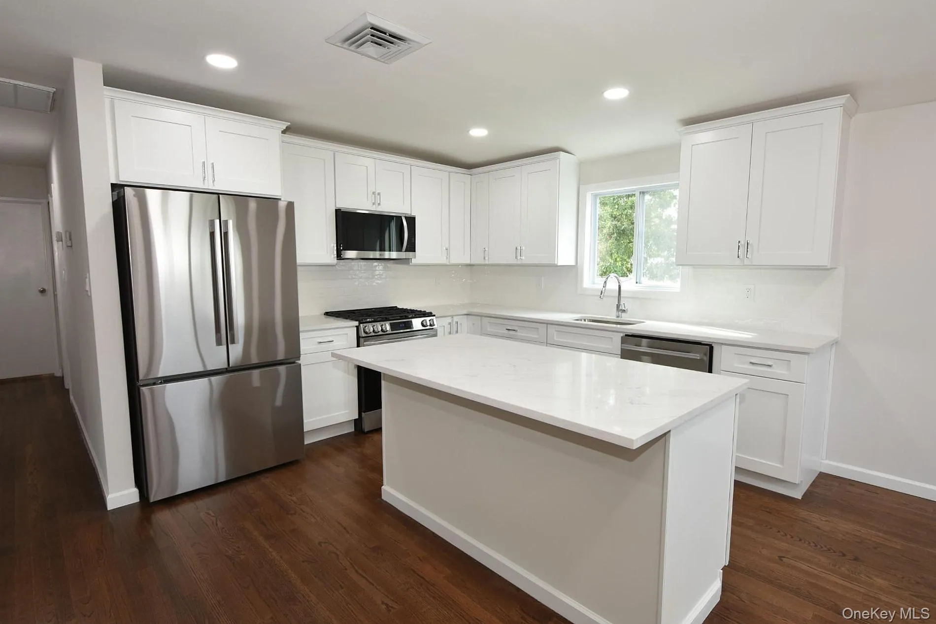 Renovated kitchen with quartz and breakfast bar island Renovated kitchen with quartz and breakfast bar island