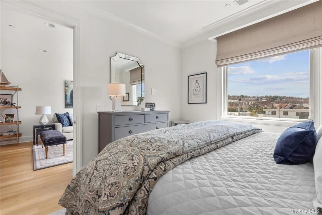 Bedroom with crown molding and light hardwood / wood-style flooring Bedroom with crown molding and light hardwood / wood-style flooring