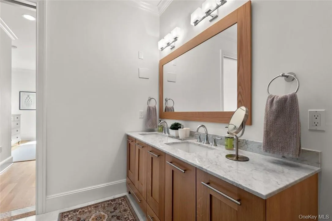 Bathroom featuring vanity, crown molding, and hardwood / wood-style flooring Bathroom featuring vanity, crown molding, and hardwood / wood-style flooring