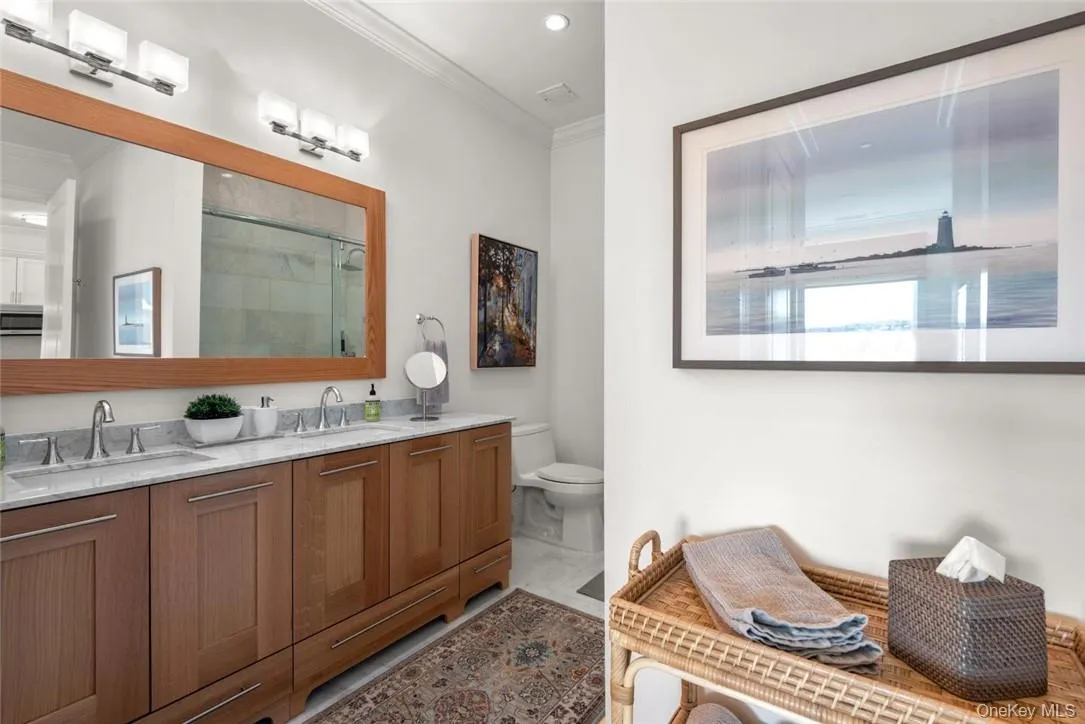 Bathroom with a shower with door, vanity, ornamental molding, and toilet Bathroom with a shower with door, vanity, ornamental molding, and toilet