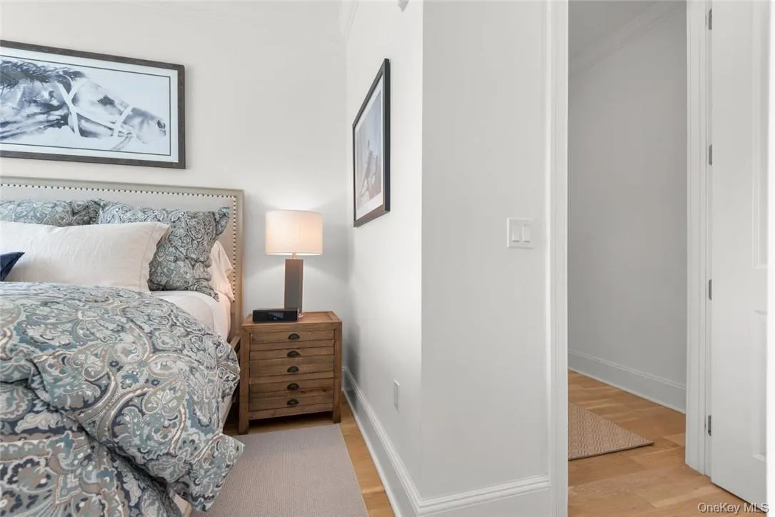 Bedroom featuring ornamental molding and light wood-type flooring Bedroom featuring ornamental molding and light wood-type flooring