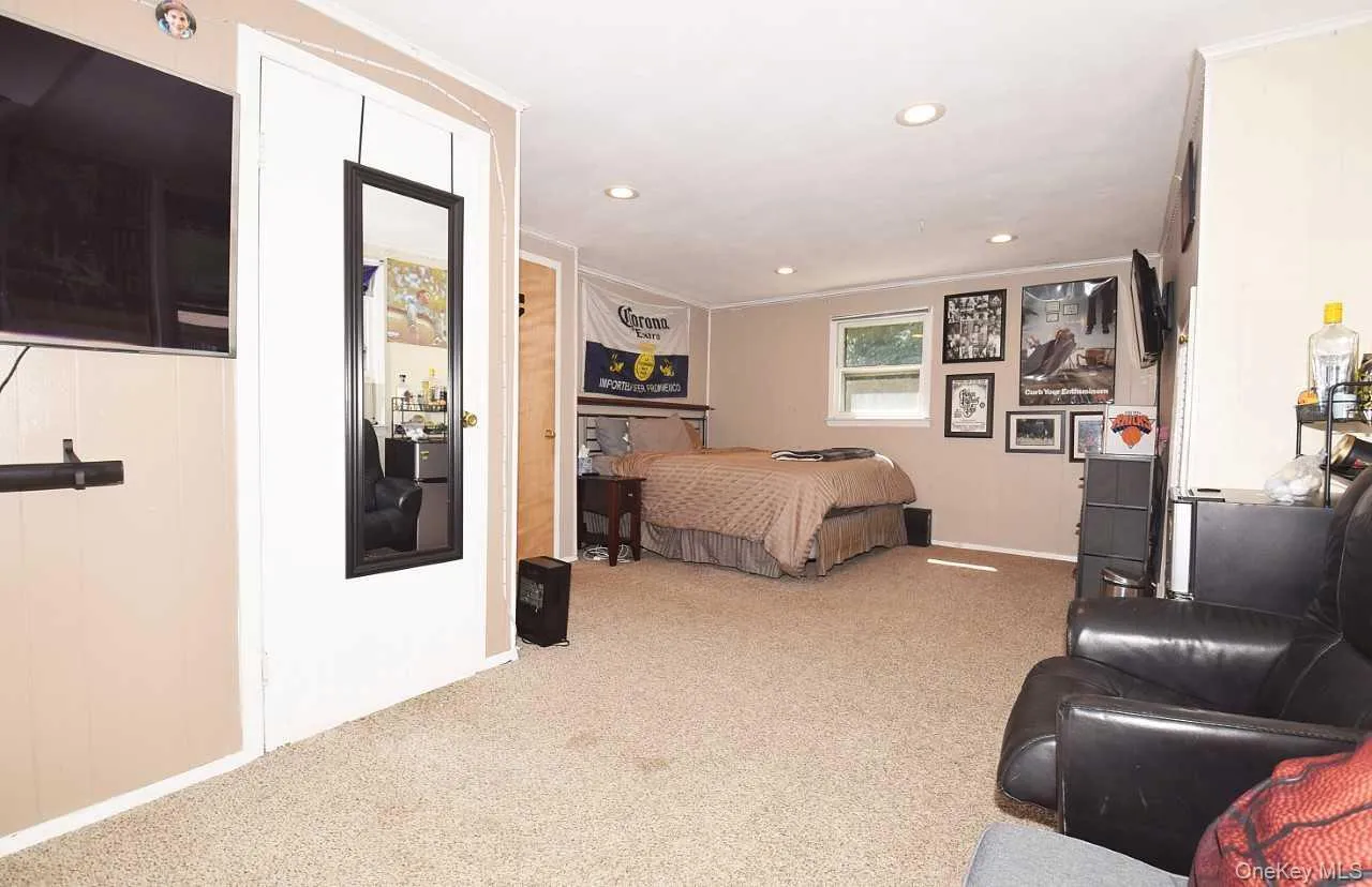 Neutral-toned walls with wainscoting, recessed lighting, and carpeting throughout Neutral-toned walls with wainscoting, recessed lighting, and carpeting throughout