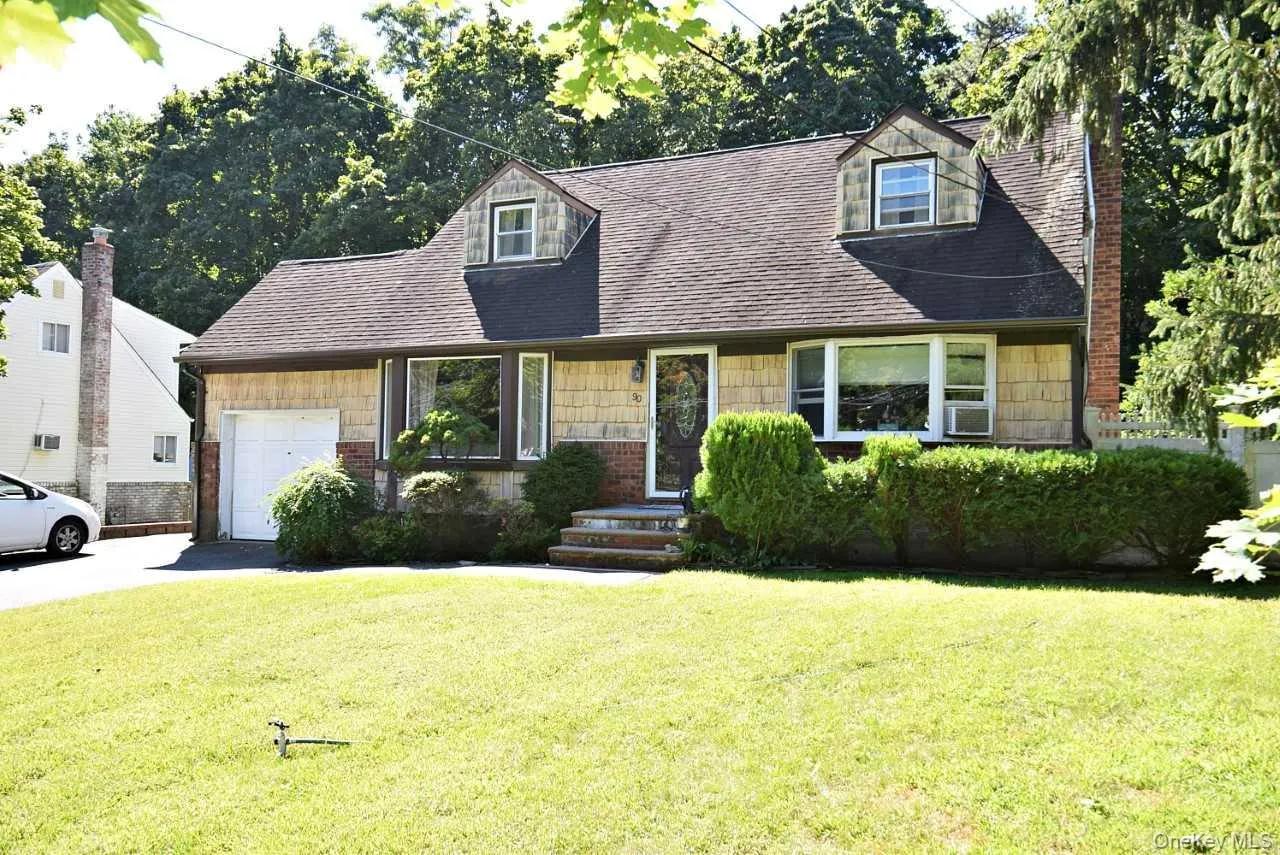 Shingle siding exterior with a dark-shingled roof and brick accents Shingle siding exterior with a dark-shingled roof and brick accents