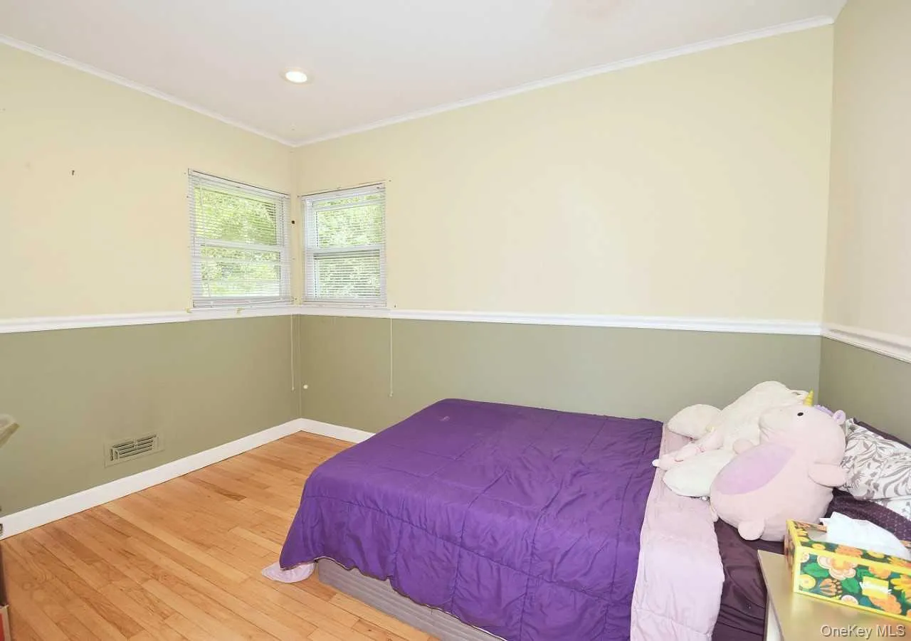 Wood-finish flooring with white trim, two windows, and recessed ceiling lighting Wood-finish flooring with white trim, two windows, and recessed ceiling lighting