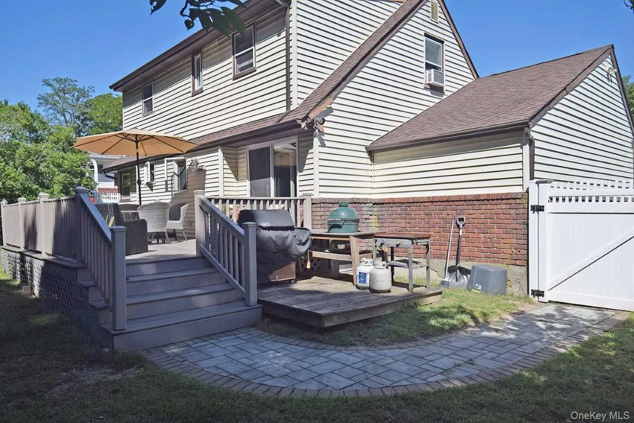 Expansive rear deck with stairs, a paver walkway, and vinyl fencing Expansive rear deck with stairs, a paver walkway, and vinyl fencing