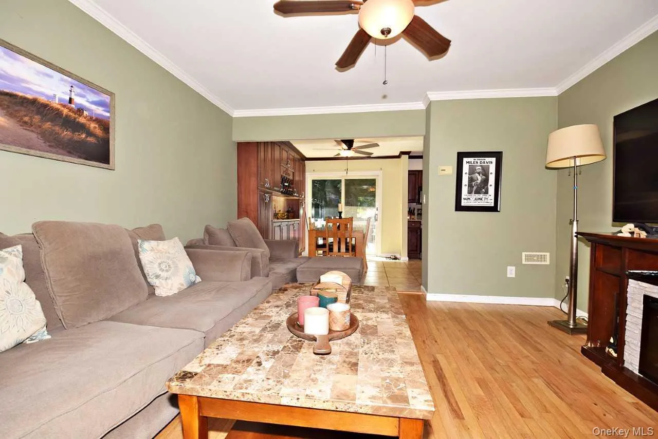 Hardwood flooring, crown molding, ceiling fan, and green wall finish Hardwood flooring, crown molding, ceiling fan, and green wall finish