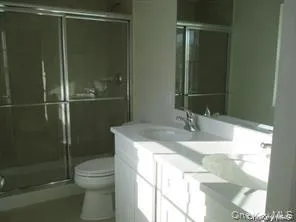 Bathroom featuring a stall shower and double vanity Bathroom featuring a stall shower and double vanity