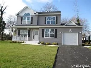 Traditional-style home with covered porch, a garage, driveway, and a front lawn Traditional-style home with covered porch, a garage, driveway, and a front lawn