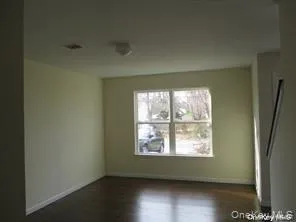 Empty room featuring dark wood-type flooring and baseboards Empty room featuring dark wood-type flooring and baseboards