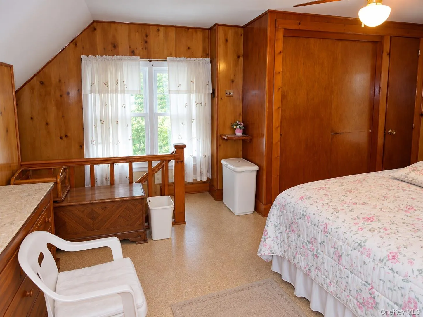 Bedroom-Wood-paneled walls and sloped ceiling with a window featuring natural light Bedroom-Wood-paneled walls and sloped ceiling with a window featuring natural light