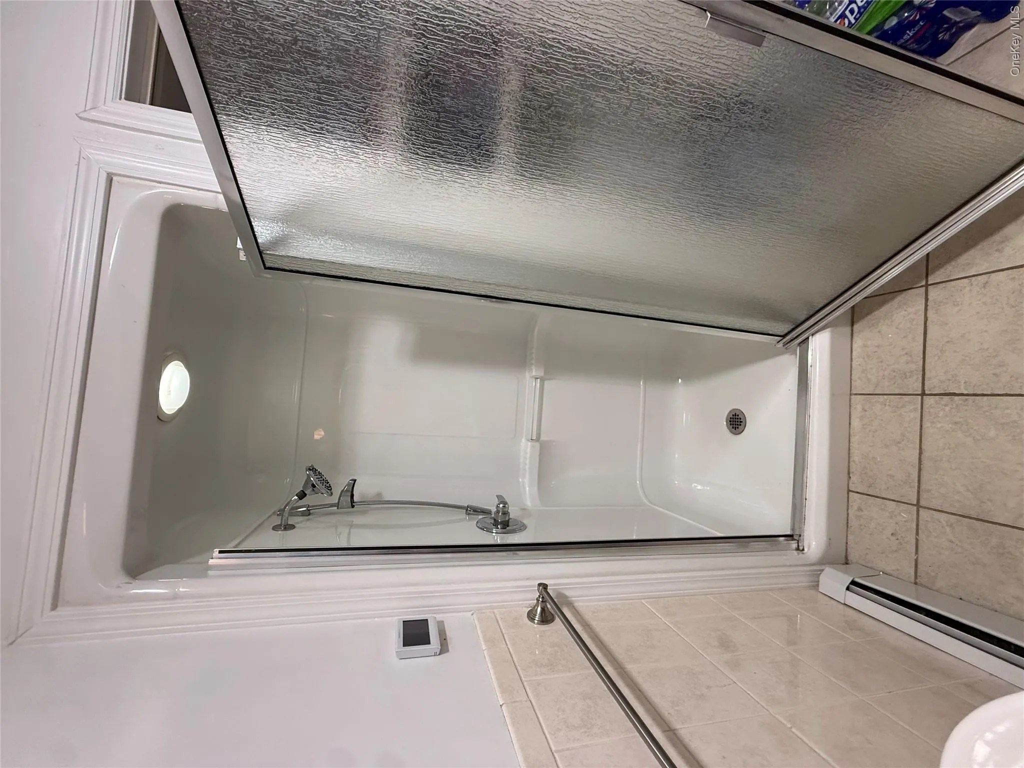 Enclosed shower stall with a textured glass door and a built-in shower seat Enclosed shower stall with a textured glass door and a built-in shower seat