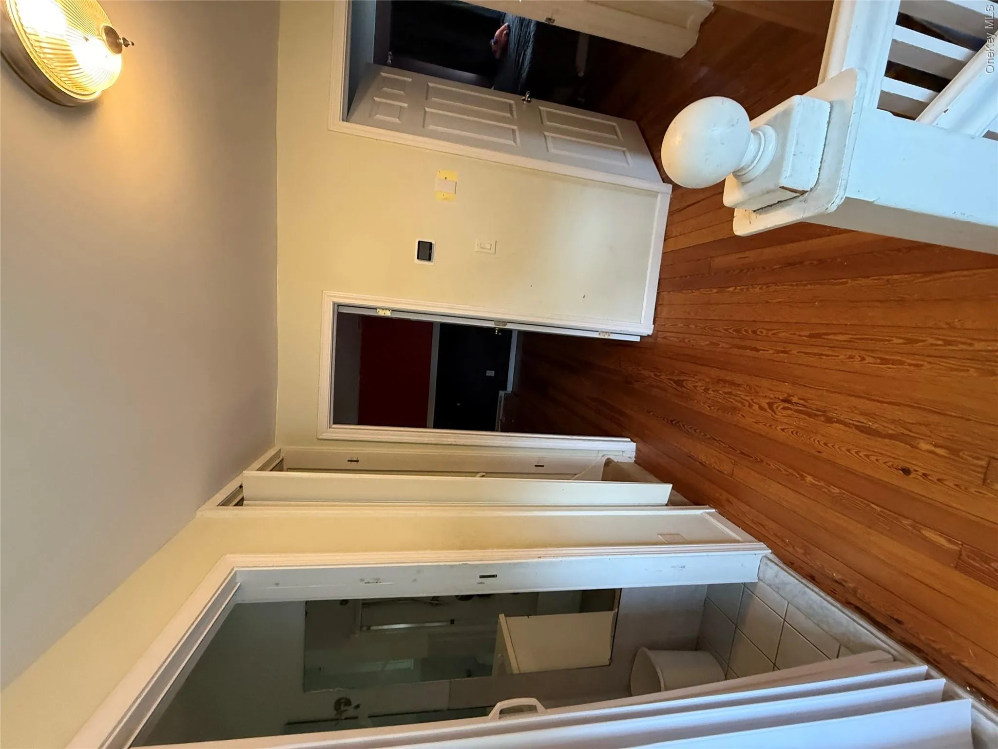 Wood-finish flooring throughout, white trim, and a flush mount ceiling light fixture Wood-finish flooring throughout, white trim, and a flush mount ceiling light fixture