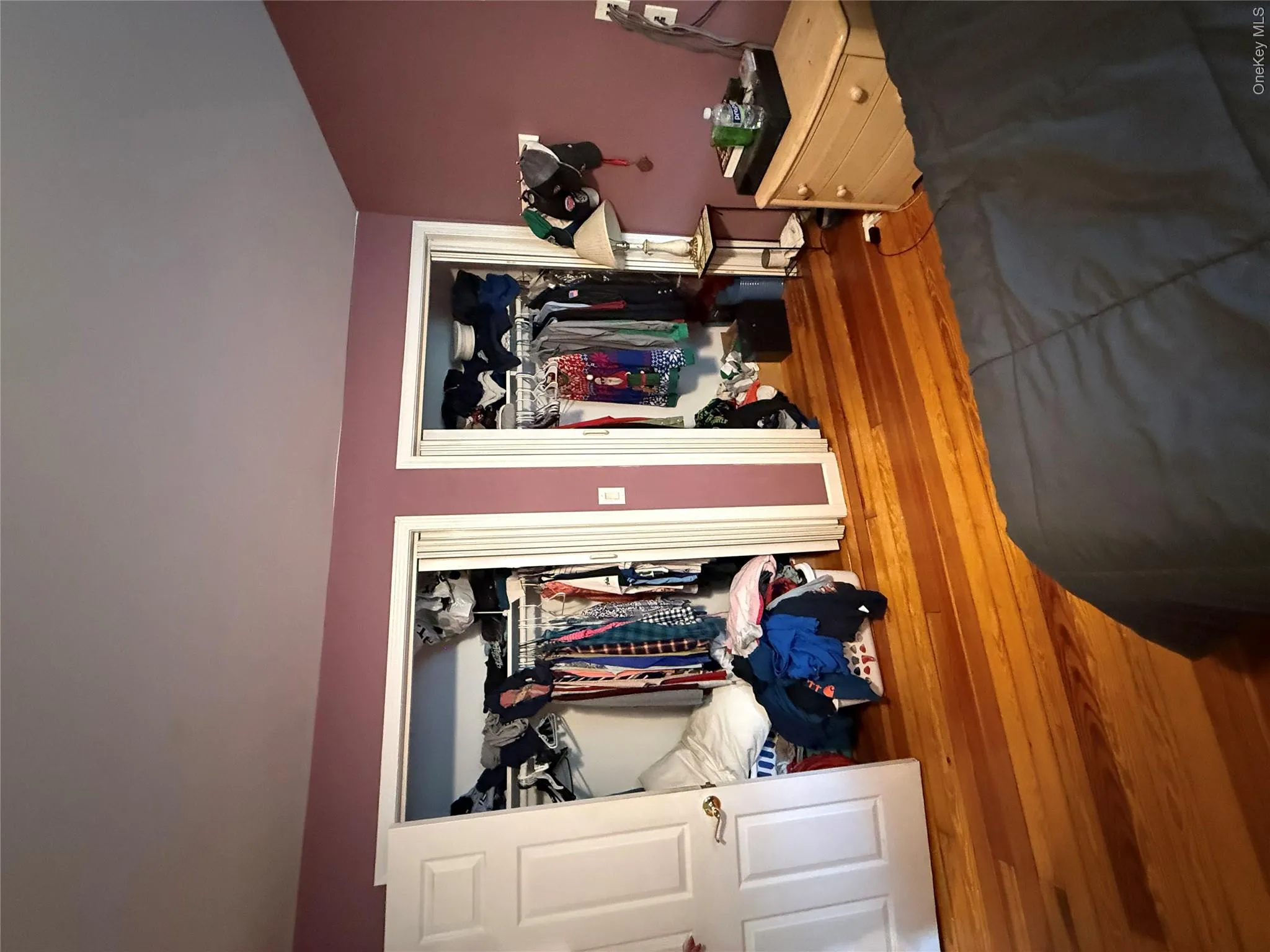 Wood-finish flooring throughout, two closet openings with white trim, and a warm-toned wall finish Wood-finish flooring throughout, two closet openings with white trim, and a warm-toned wall finish