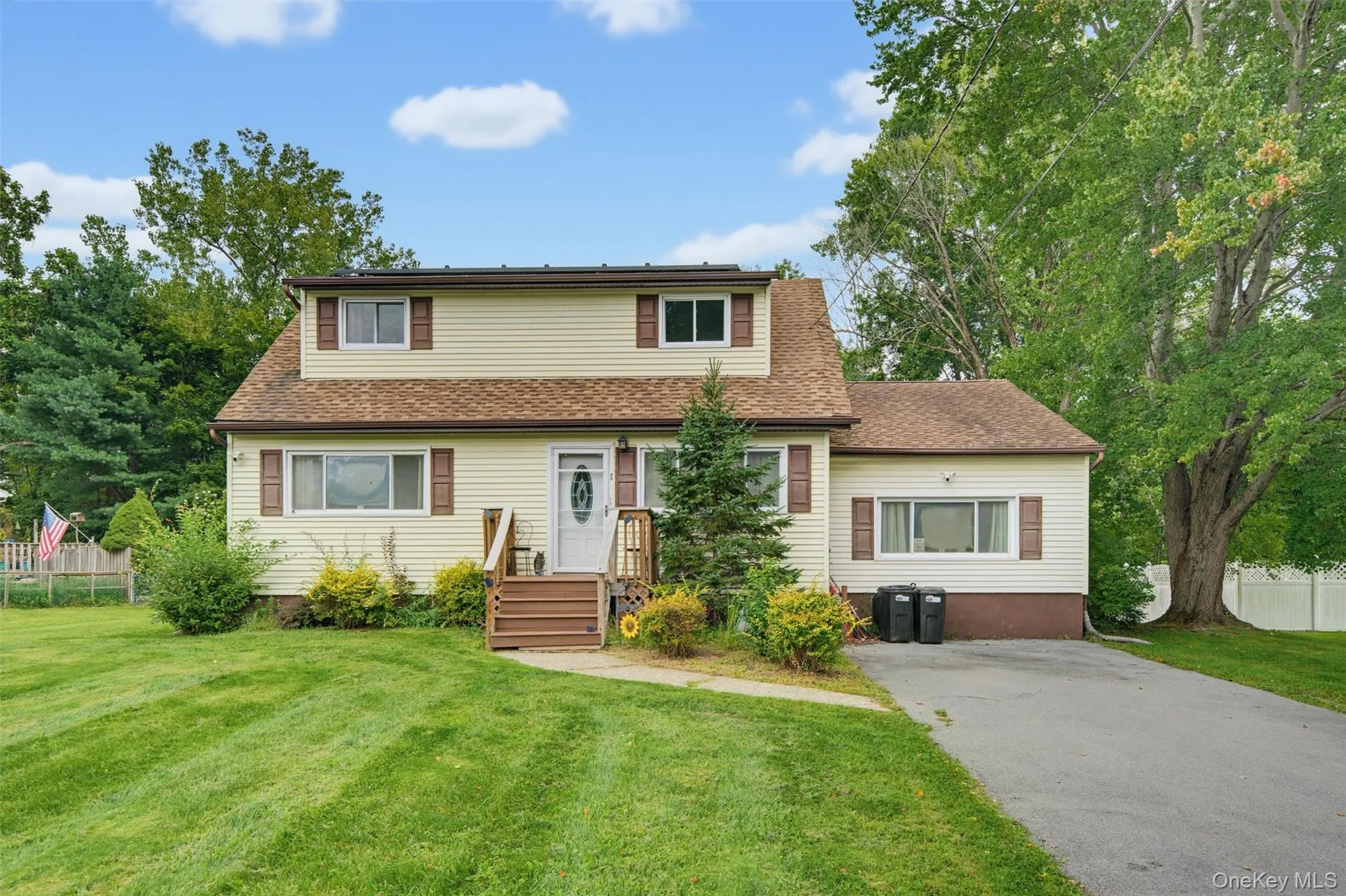 Two-story residence with light-colored siding and brown window shutters Two-story residence with light-colored siding and brown window shutters