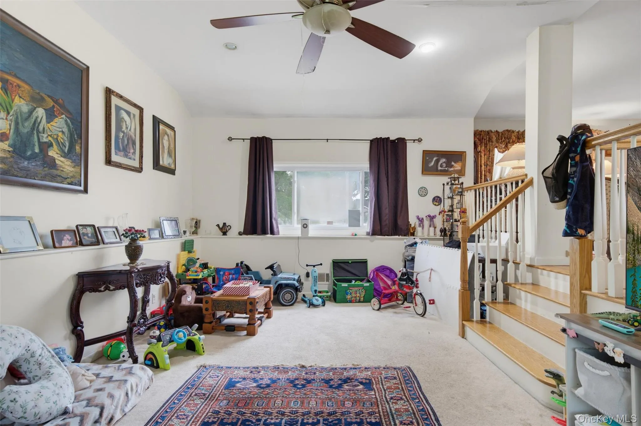 Carpeted flooring, ceiling fan, recessed lighting, and a wood-finish staircase with white risers Carpeted flooring, ceiling fan, recessed lighting, and a wood-finish staircase with white risers