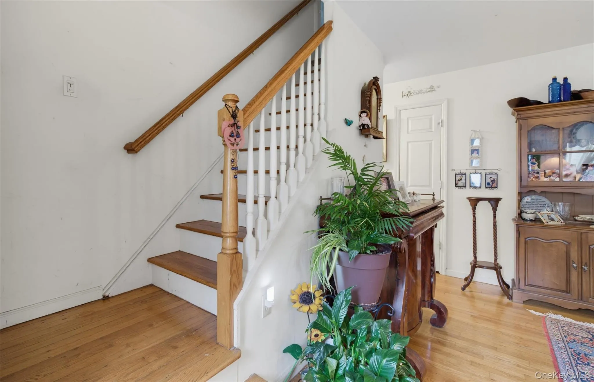 Hardwood flooring and a staircase featuring white painted risers with wooden treads and handrails Hardwood flooring and a staircase featuring white painted risers with wooden treads and handrails