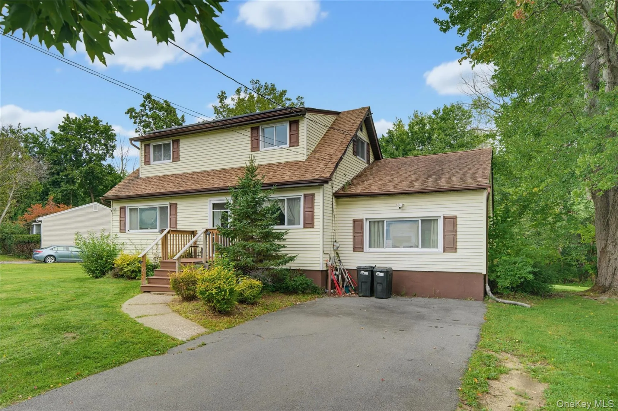 Two-story residence featuring light-colored siding, contrasting brown shutters, and a multi-pitch roof Two-story residence featuring light-colored siding, contrasting brown shutters, and a multi-pitch roof