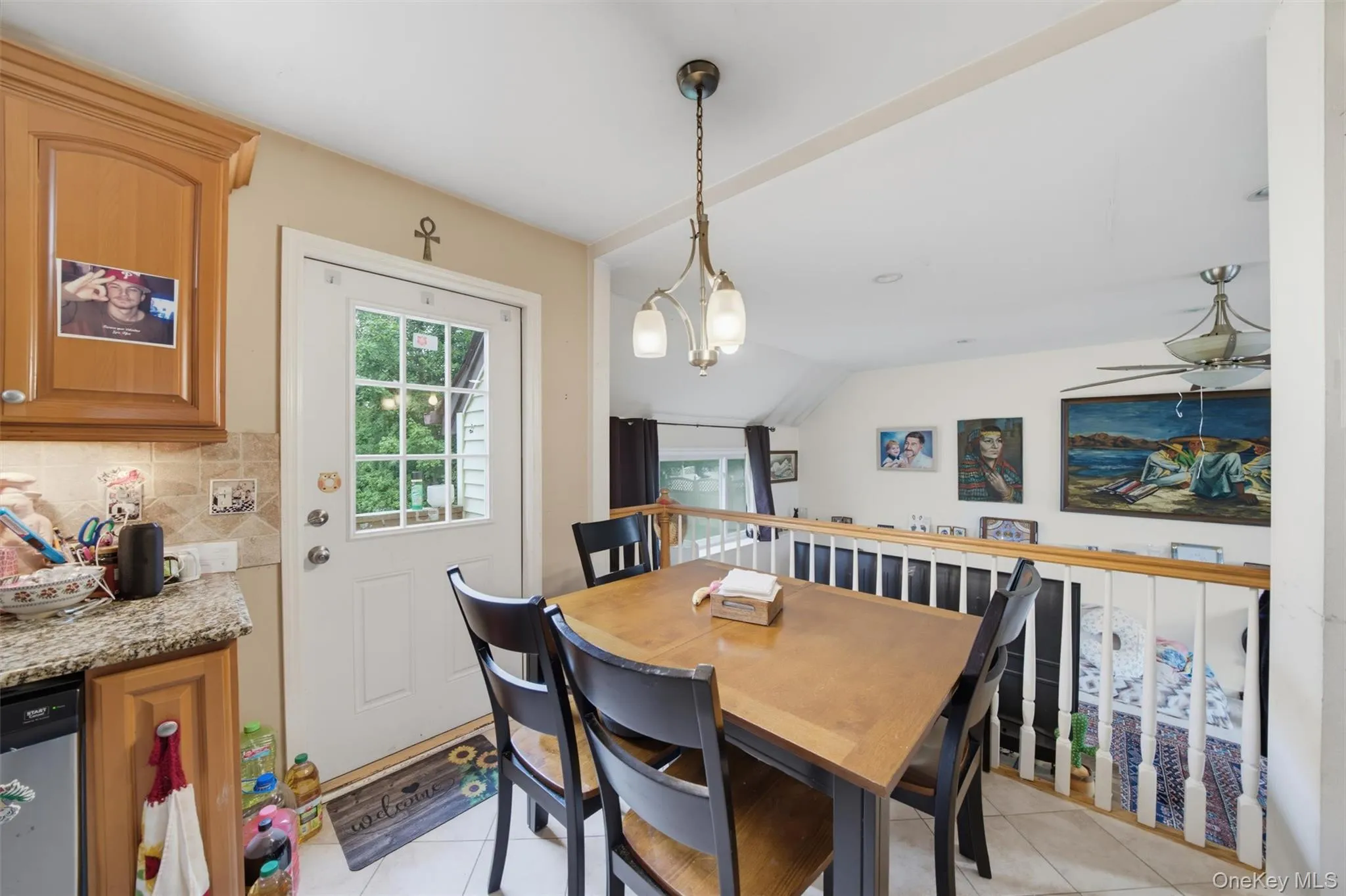 Dining area featuring wood-finish cabinetry, granite-style countertops, and a tiled backsplash Dining area featuring wood-finish cabinetry, granite-style countertops, and a tiled backsplash