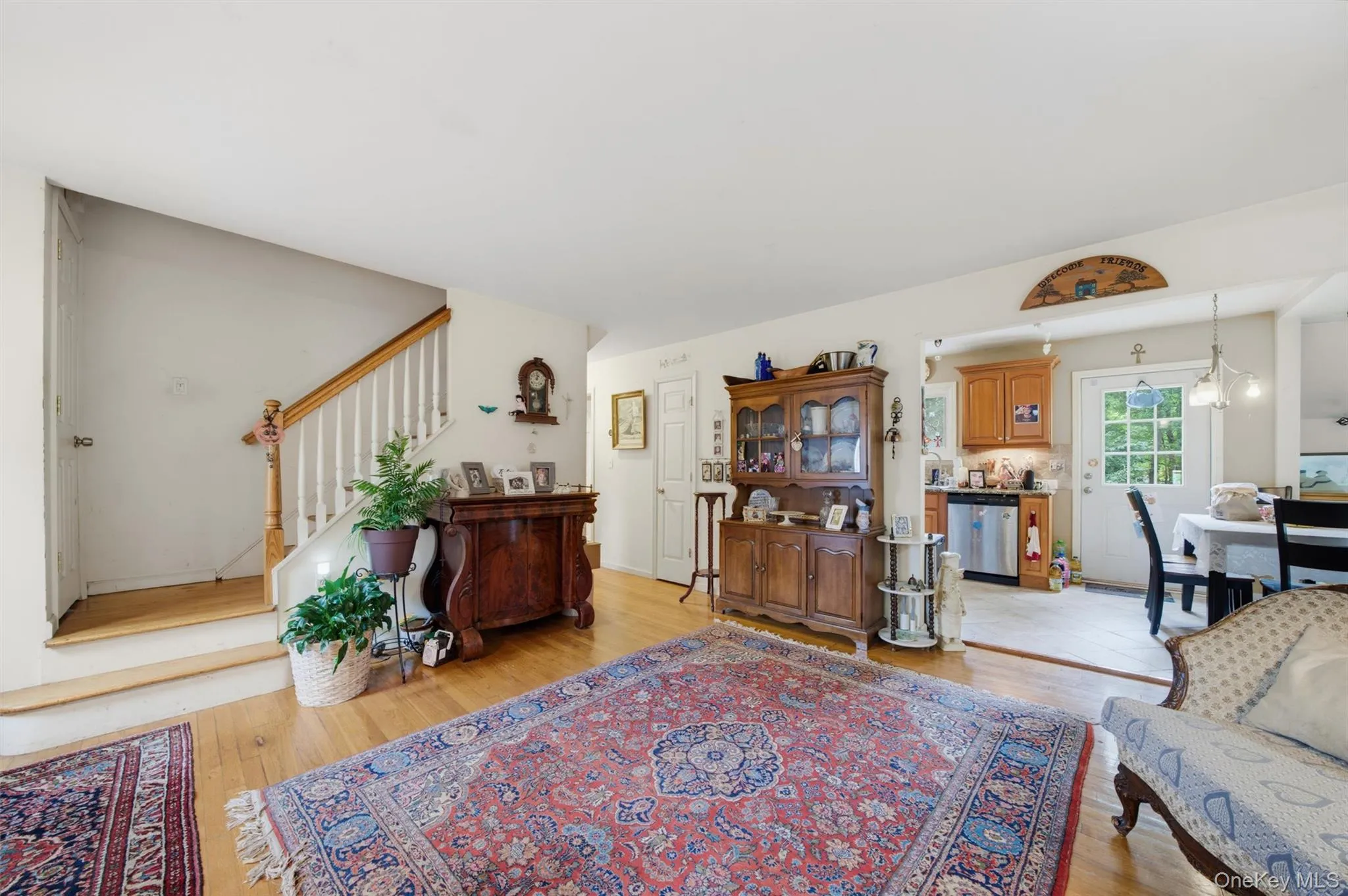 Hardwood flooring, painted white walls, and a wood staircase with white balusters Hardwood flooring, painted white walls, and a wood staircase with white balusters
