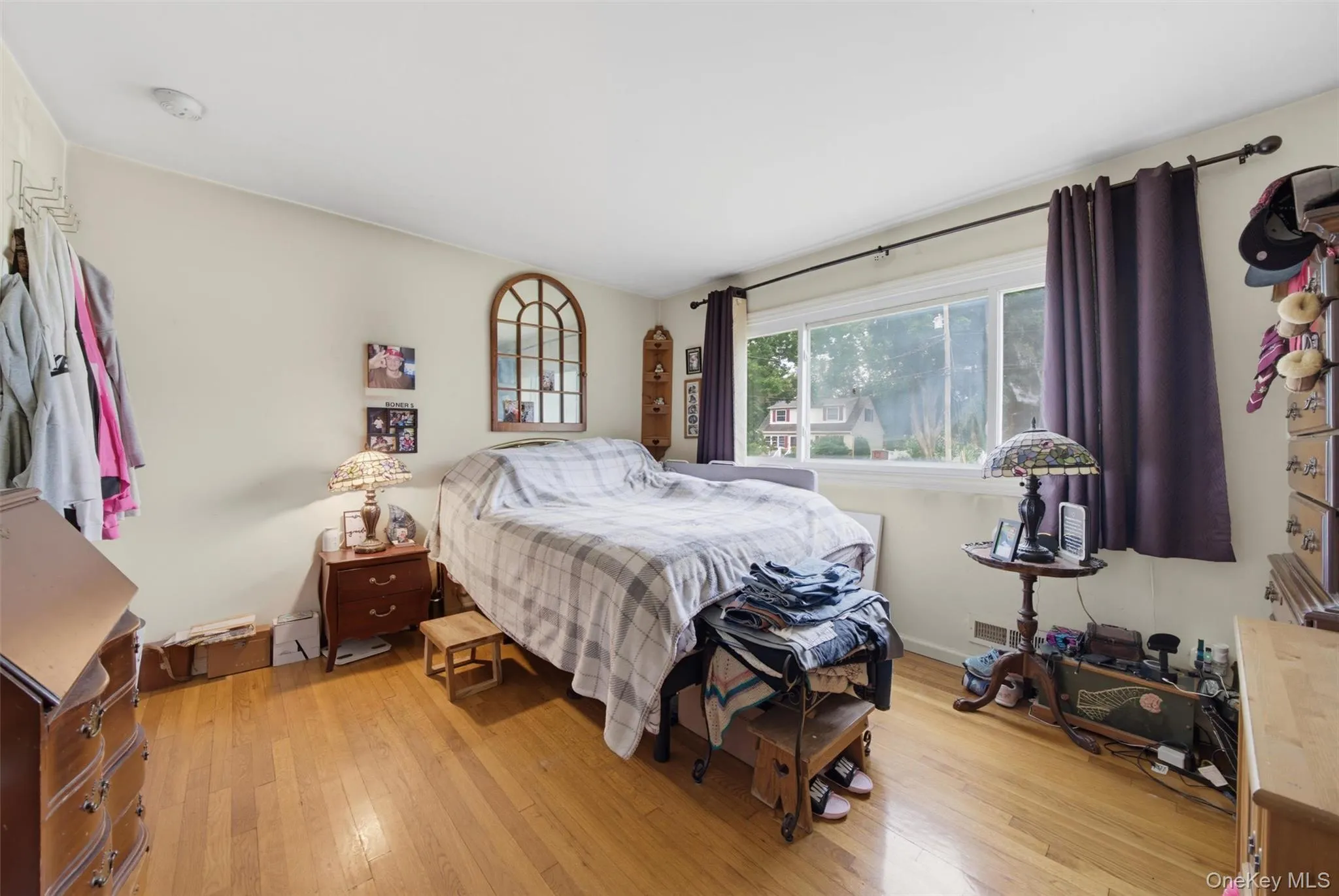 Hardwood flooring, painted walls, and a large window with privacy curtains Hardwood flooring, painted walls, and a large window with privacy curtains