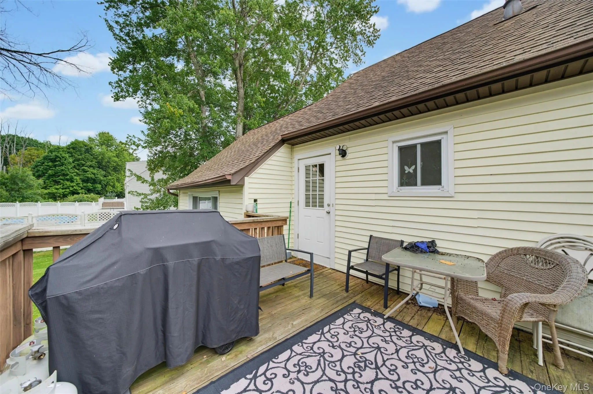 Expansive outdoor deck featuring wood flooring, fencing, and a light-colored siding exterior Expansive outdoor deck featuring wood flooring, fencing, and a light-colored siding exterior