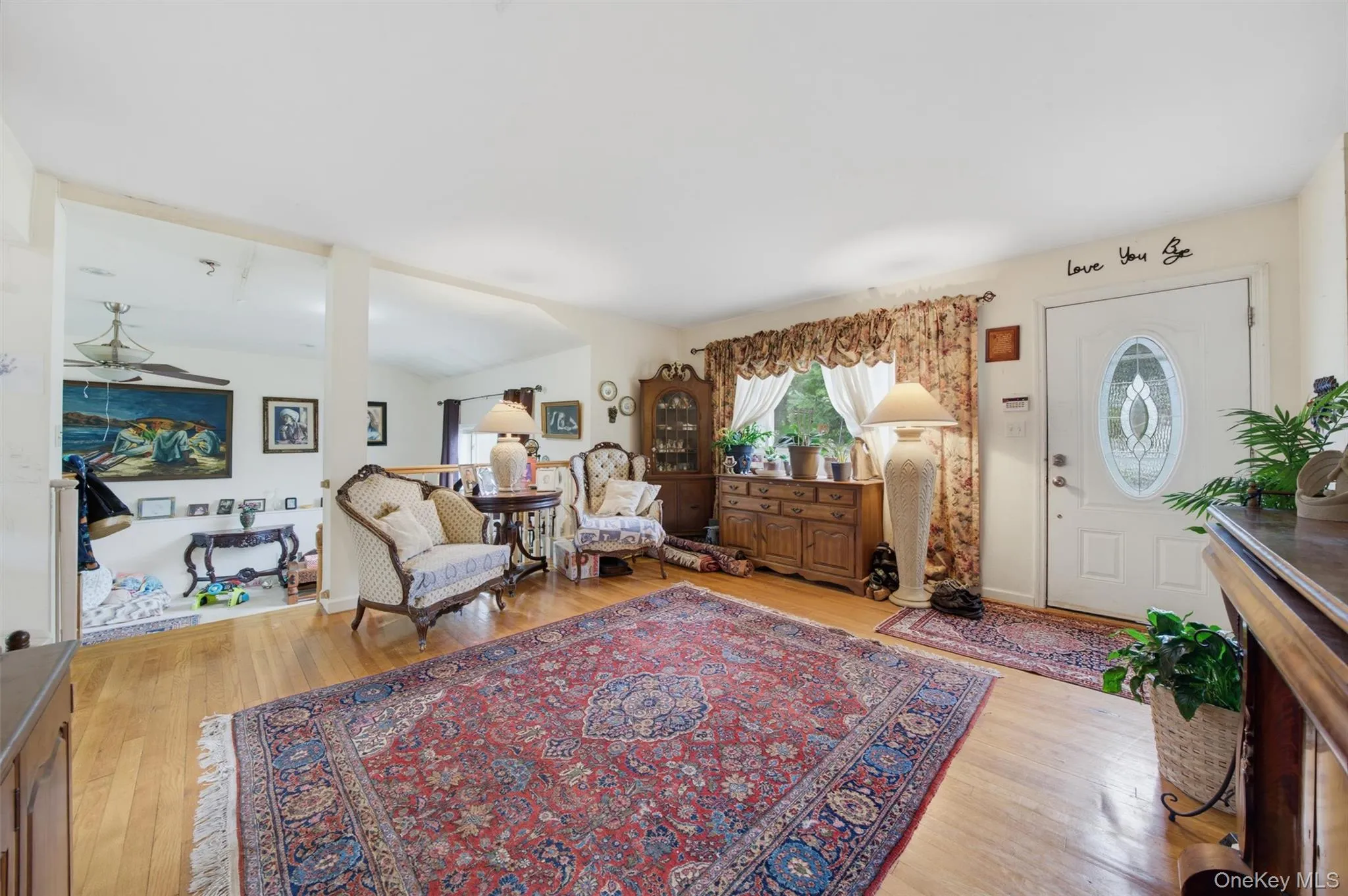 Hardwood-style flooring throughout, an oval-paneled entry door, and a built-in wood-finish cabinet Hardwood-style flooring throughout, an oval-paneled entry door, and a built-in wood-finish cabinet