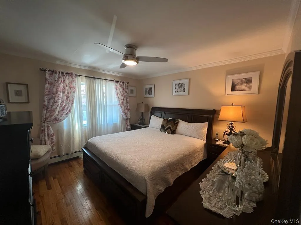 Wood-finish flooring, crown molding, and a ceiling fan with integrated lighting Wood-finish flooring, crown molding, and a ceiling fan with integrated lighting